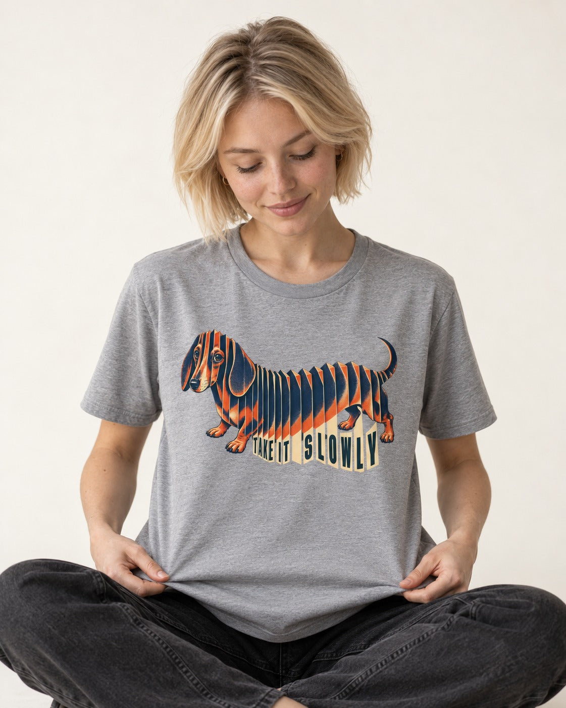 Take It Slowly Dachshund T-Shirt in Sport Grey, worn by a seated model