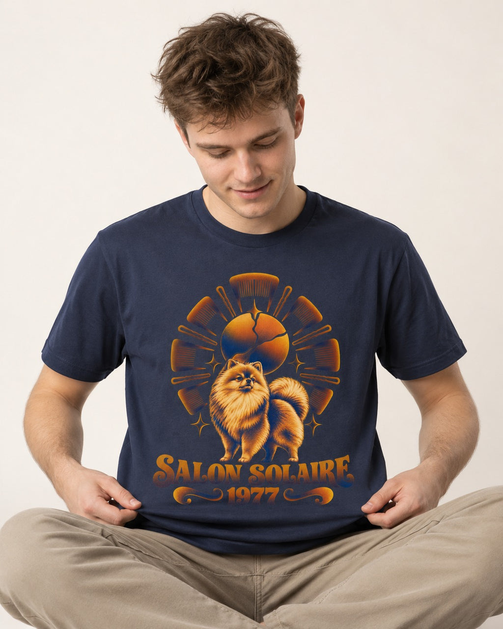 Pomeranian Salon Solaire 1977 Hairbrush Halo Graphic T-Shirt in Navy, worn by a seated model