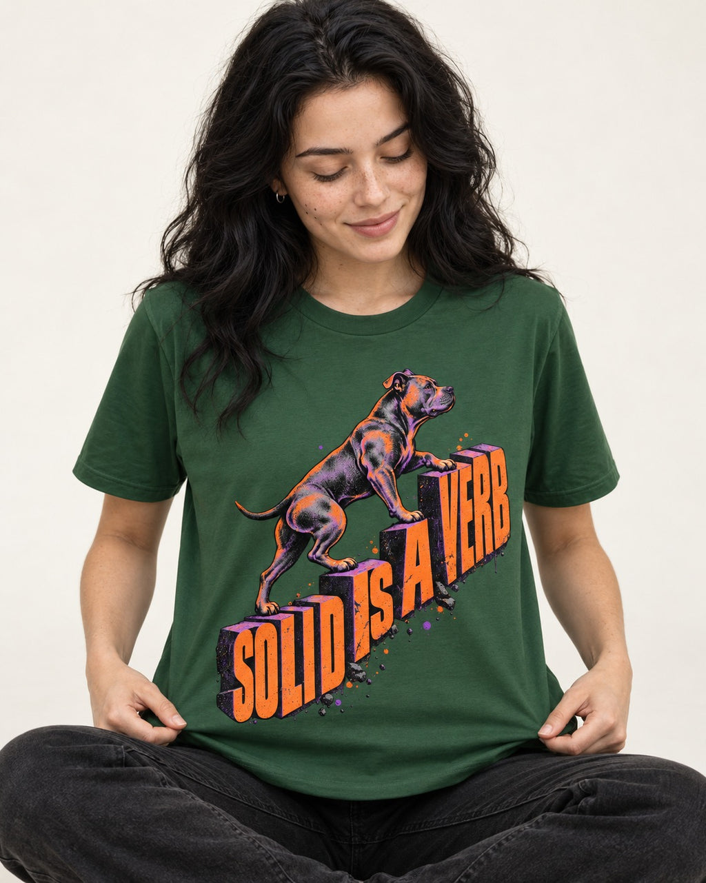 Pitbull Solid Is a Verb Step Type Graphic T-Shirt in Forest Green, worn by a seated model