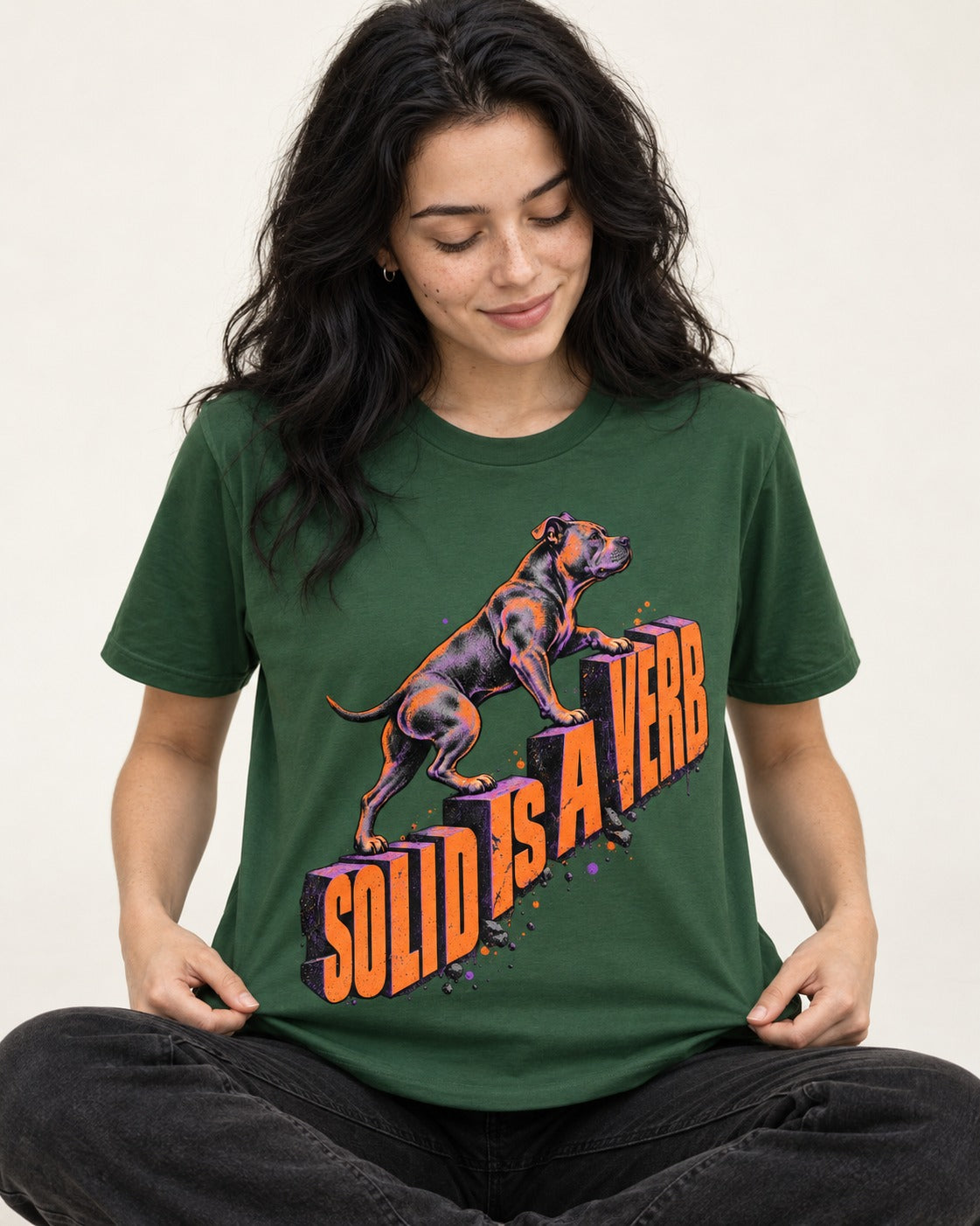 Pitbull Solid Is a Verb Step Type Graphic T-Shirt in Forest Green, worn by a seated model
