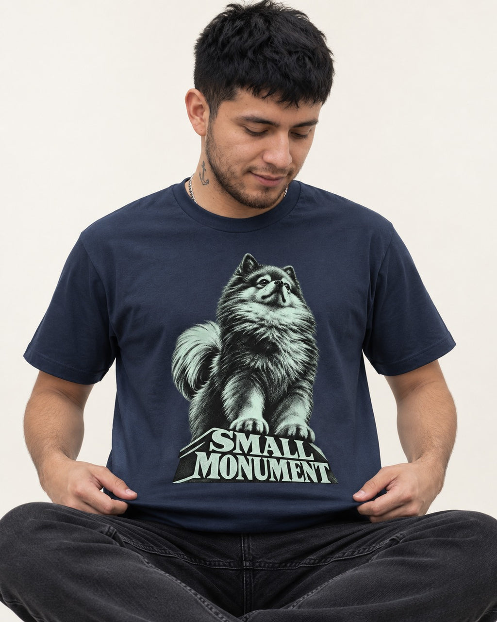 Pomeranian Small Monument Pedestal Graphic T-Shirt in Navy, worn by a seated model