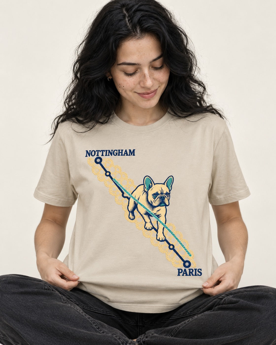 Nottingham to Paris Frenchie T-Shirt in Sand, worn by a seated model