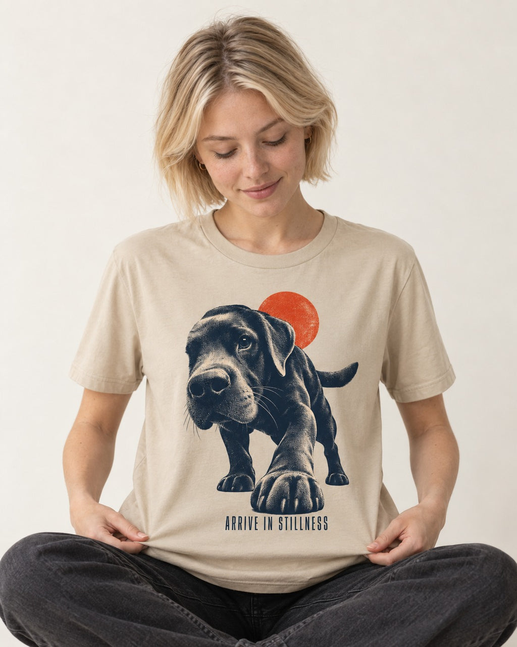 Labrador Retriever Arrive in Stillness T-Shirt in Sand, worn by a seated model