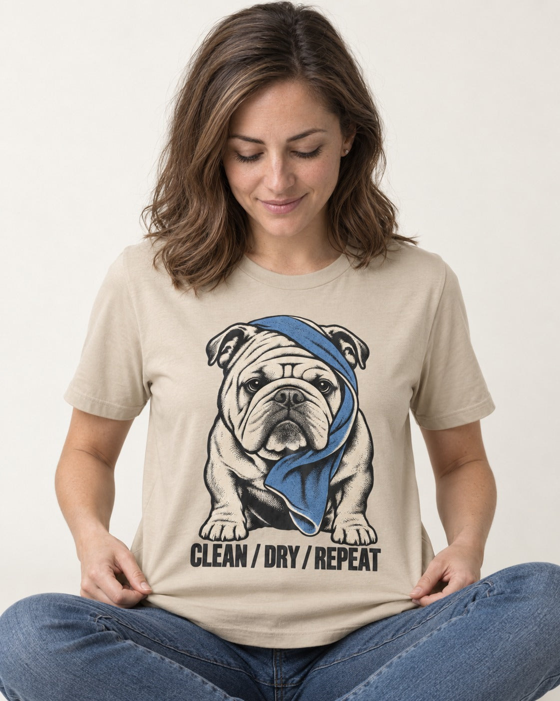 Clean Dry Repeat English Bulldog T-Shirt in Sand, worn by a seated model