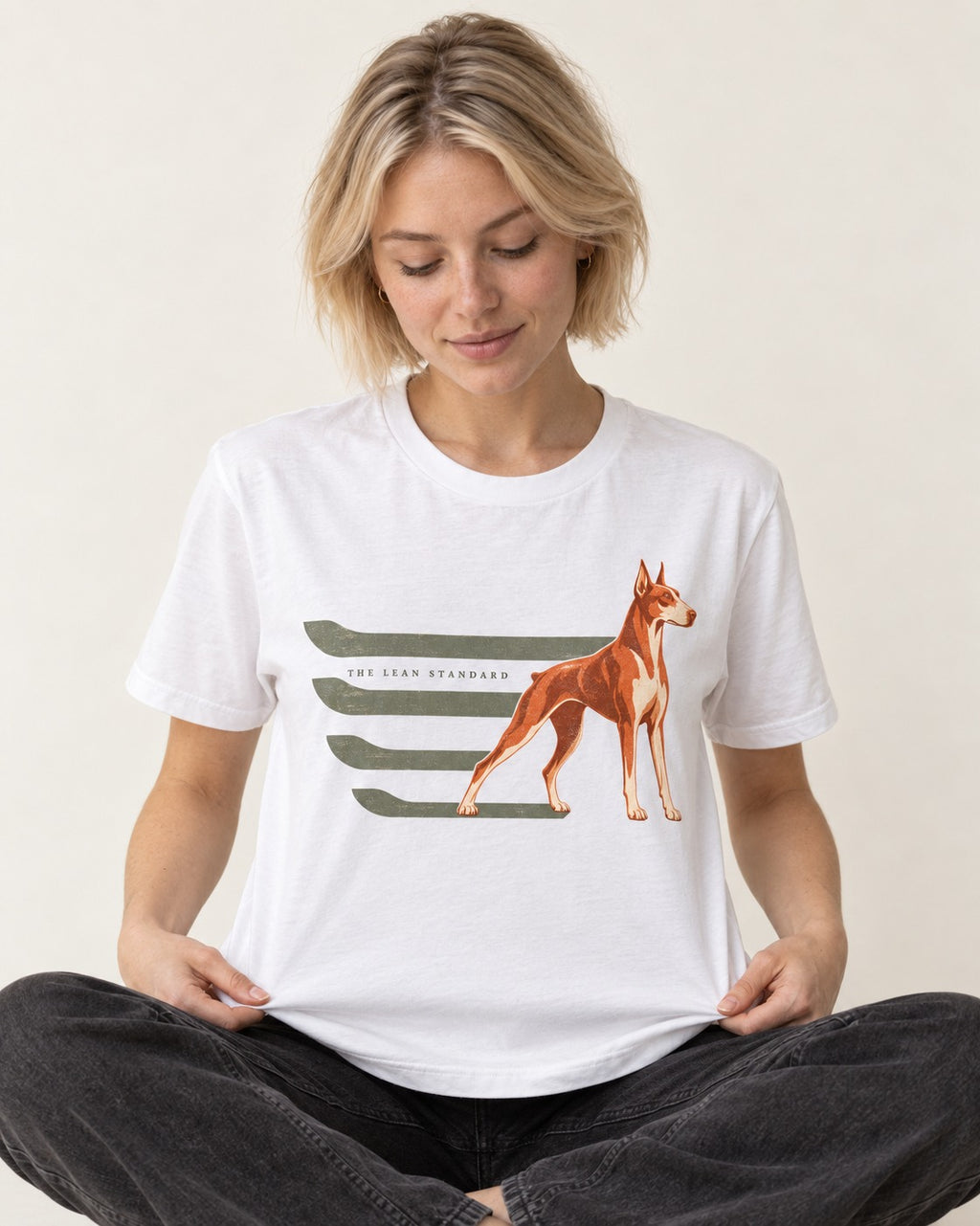 Doberman The Lean Standard Speed Bars Graphic T-Shirt in White, worn by a seated model
