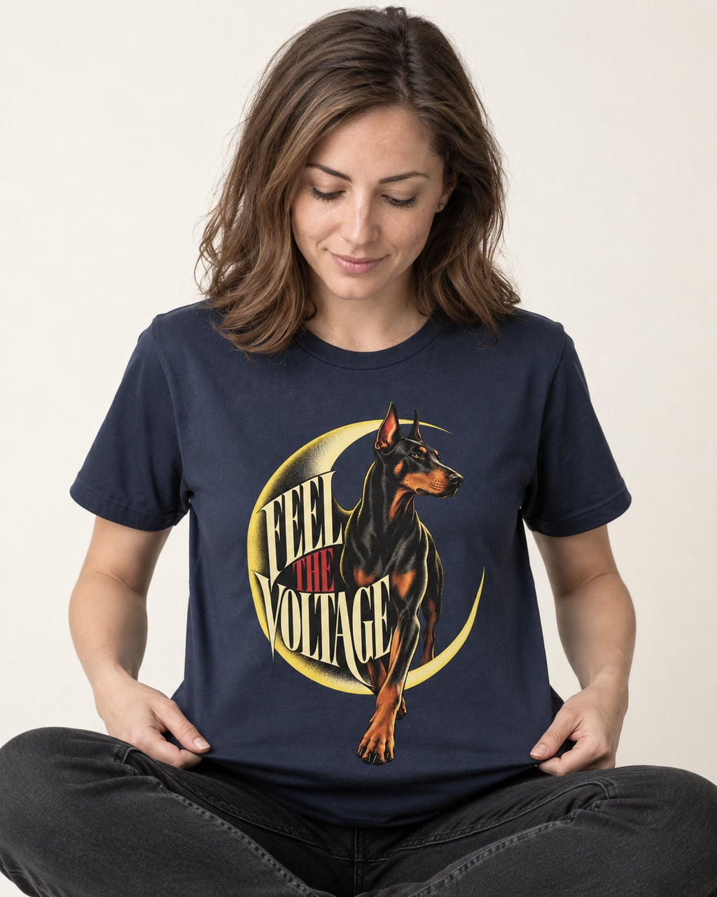 Doberman Feel the Voltage Crescent Portrait Graphic T-Shirt in Navy, worn by a seated model