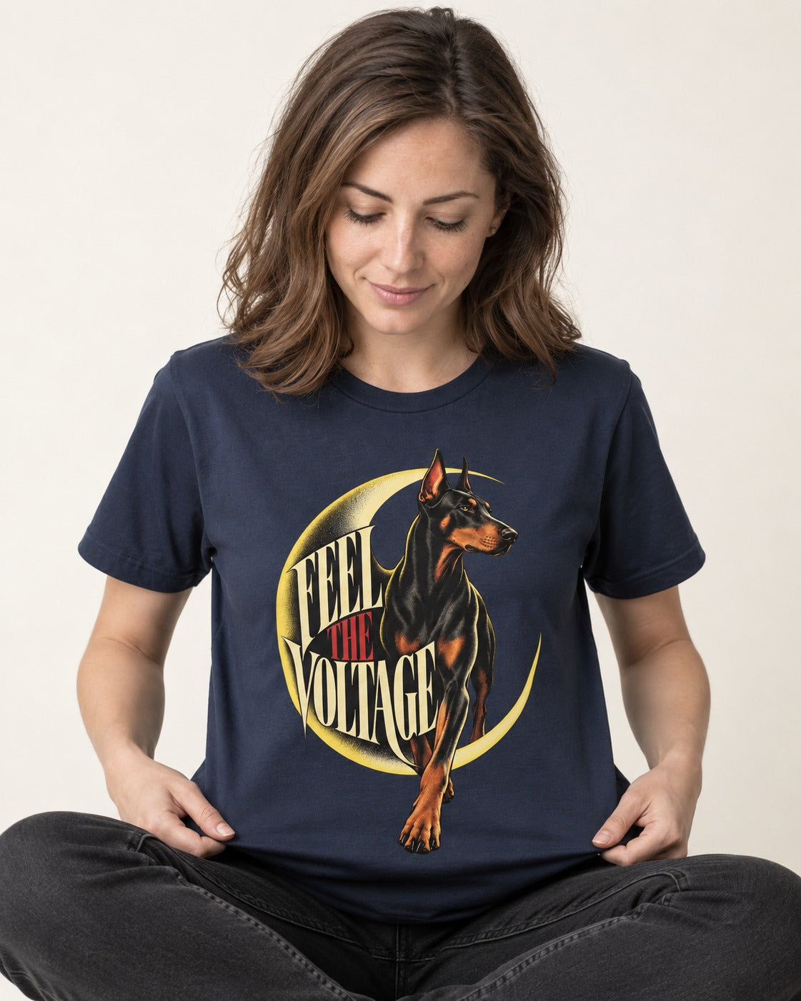 Doberman Feel the Voltage Crescent Portrait Graphic T-Shirt in Navy, worn by a seated model