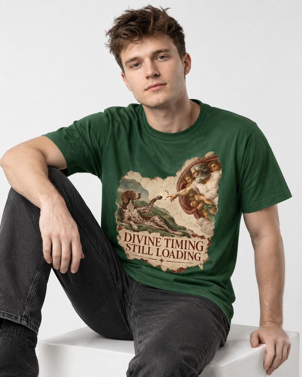 German Shorthaired Pointer Divine Timing Still Loading Creation Scene Graphic T-Shirt in Forest Green, worn by a seated model