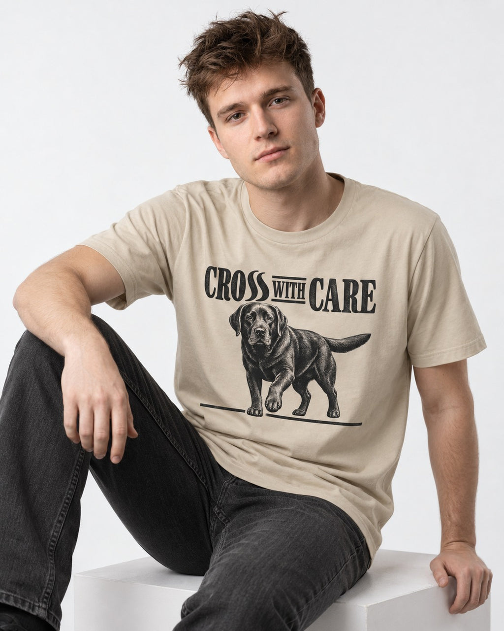 Labrador Retriever Cross with Care T-Shirt in Sand, worn by a seated model