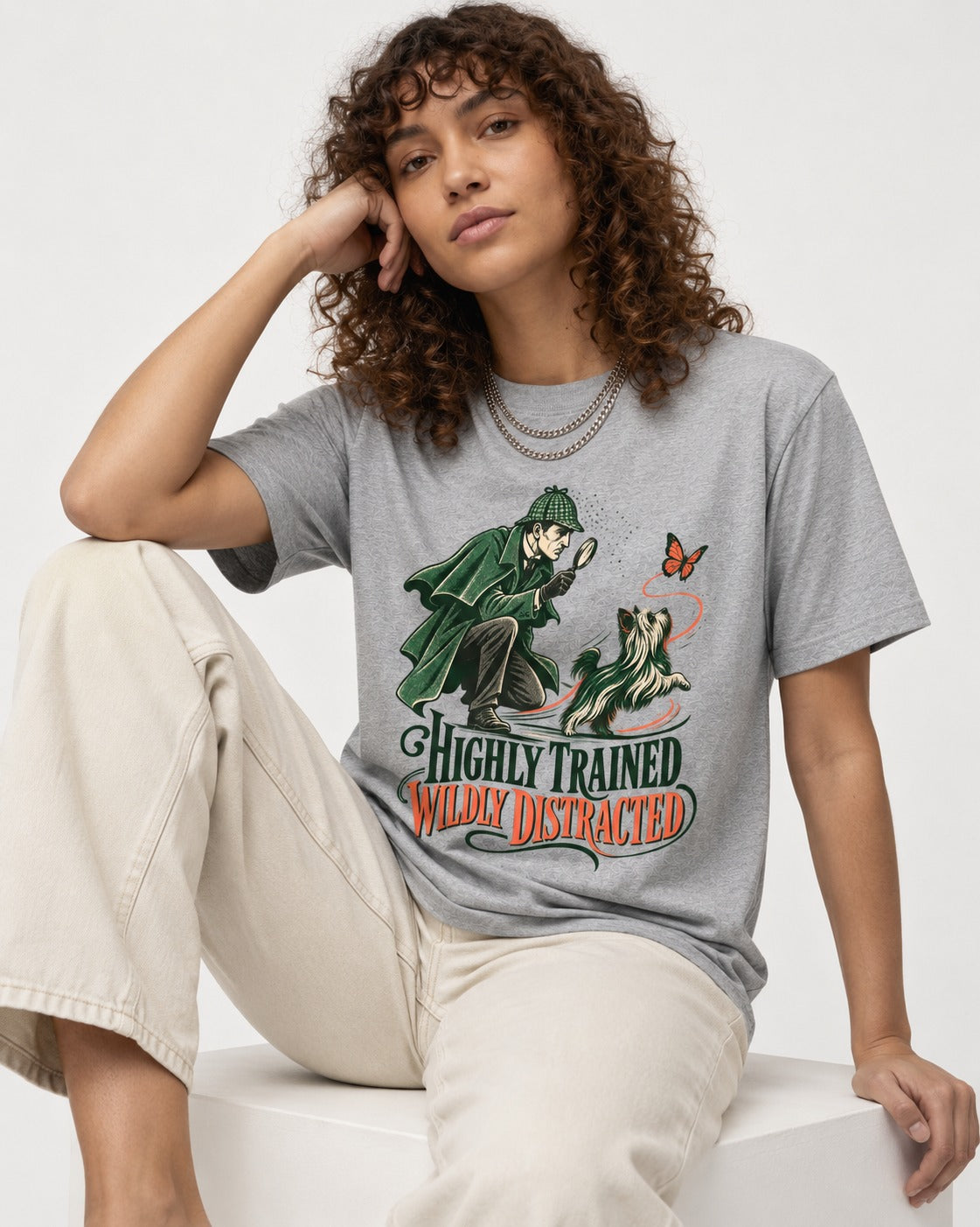 Highly Trained Wildly Distracted Yorkshire Terrier T-Shirt in Sport Grey, worn by a seated model