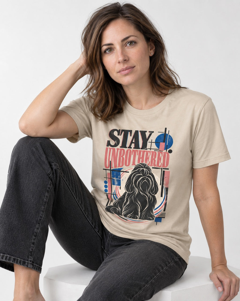 Stay Unbothered Shih Tzu T-Shirt in Sand, worn by a seated model