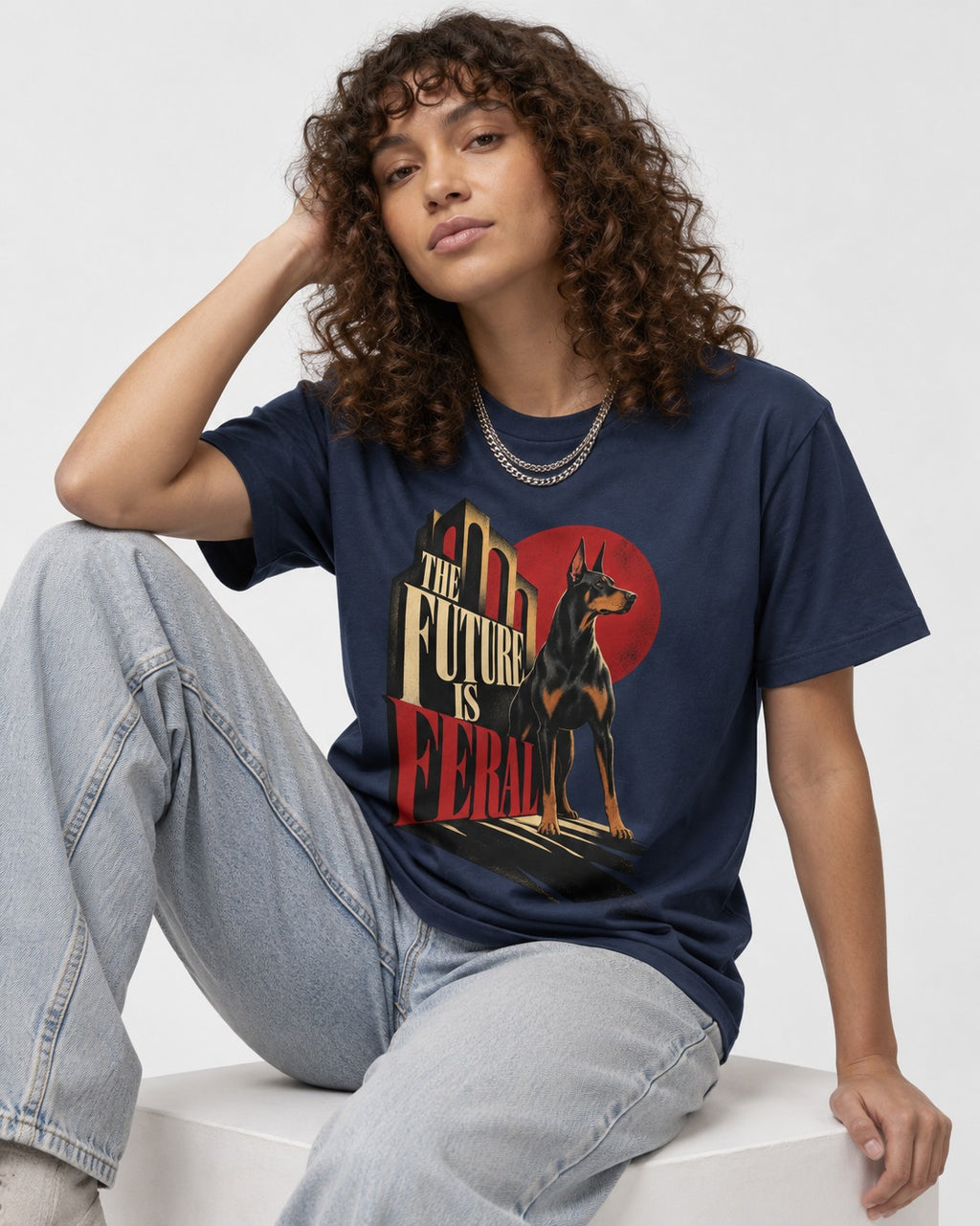 Doberman The Future Is Feral Art Deco Graphic T-Shirt in Navy, worn by a seated model