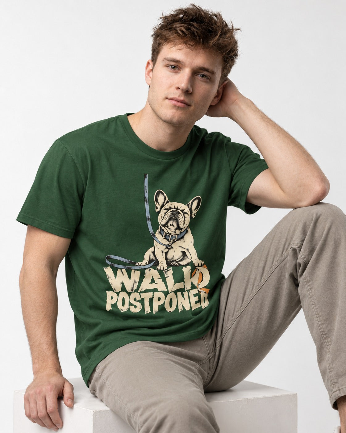 Frenchie Walk Postponed Leash Graphic T-Shirt in Forest Green, worn by a seated model