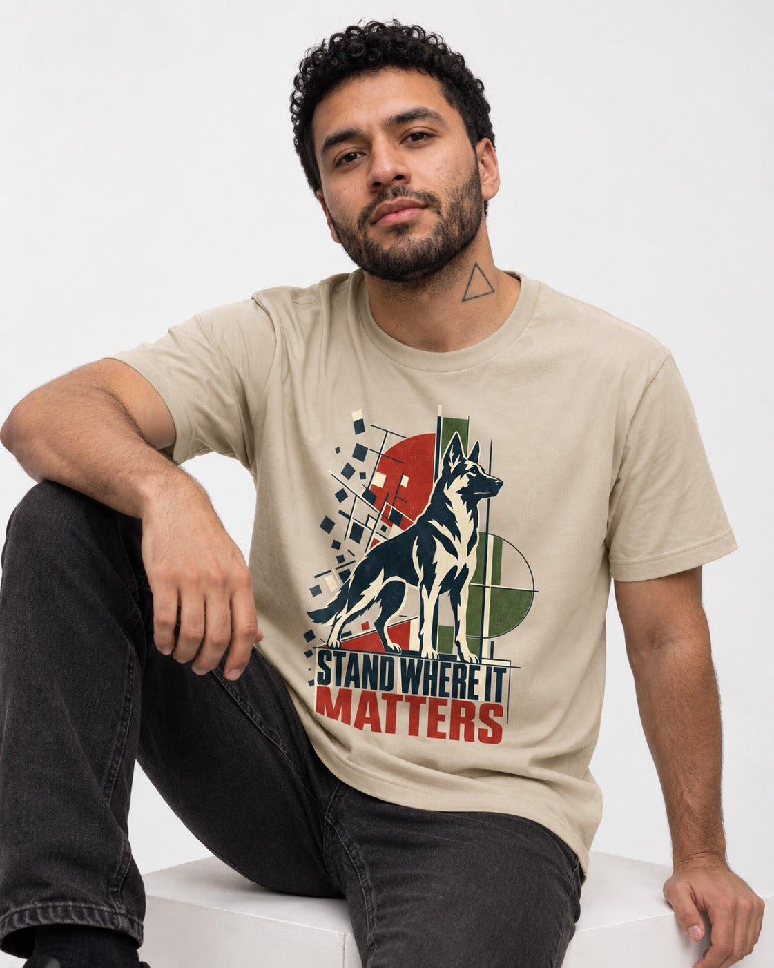 Stand Where It Matters German Shepherd Dog T-Shirt in Sand, worn by a seated model