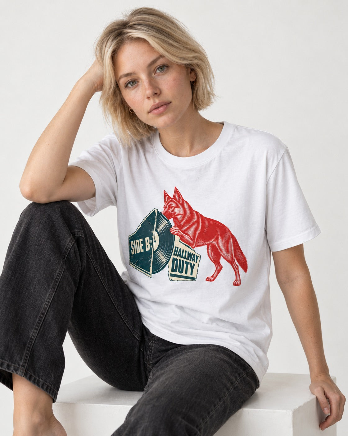 Side B Hallway Duty Vinyl Record German Shepherd Dog Graphic T-Shirt in White, worn by a seated model