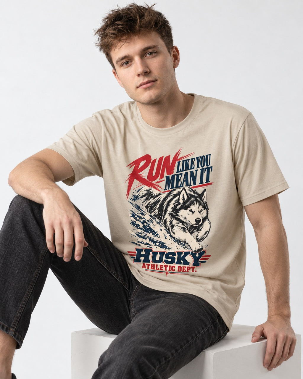 Husky Run with Purpose T-Shirt in Sand, worn by a seated model