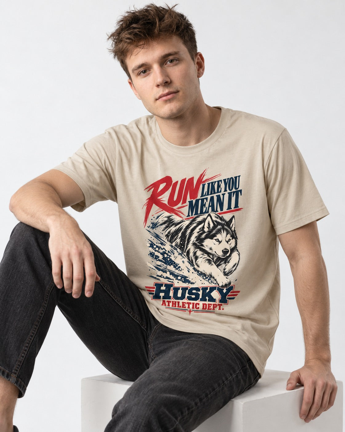 Husky Run with Purpose T-Shirt in Sand, worn by a seated model
