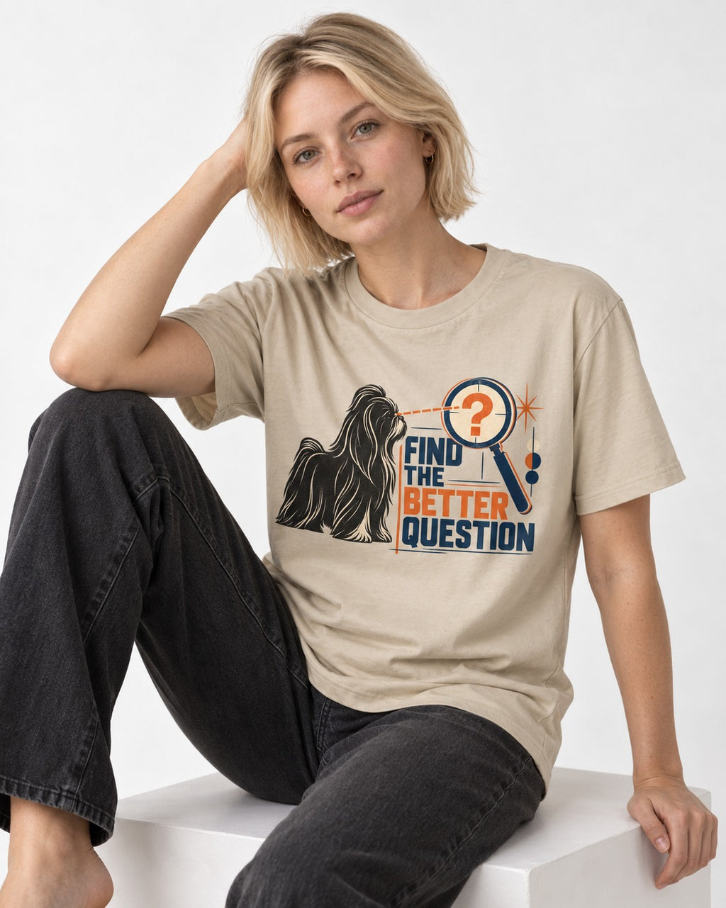 Find the Better Question Shih Tzu T-Shirt in Sand, worn by a seated model