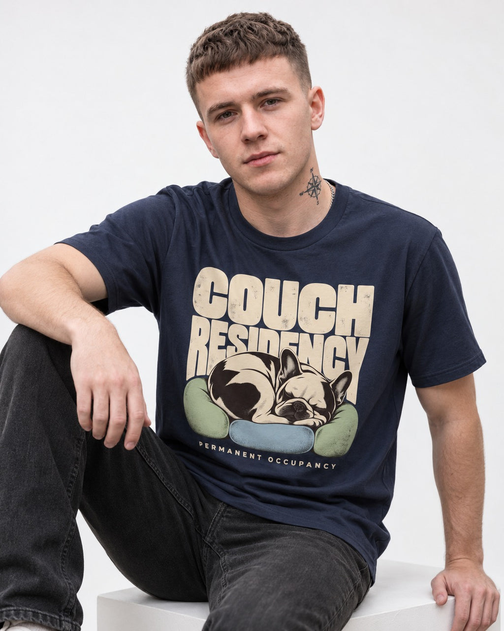 Frenchie Couch Residency Permanent Occupancy Cushion Graphic T-Shirt in Navy, worn by a seated model