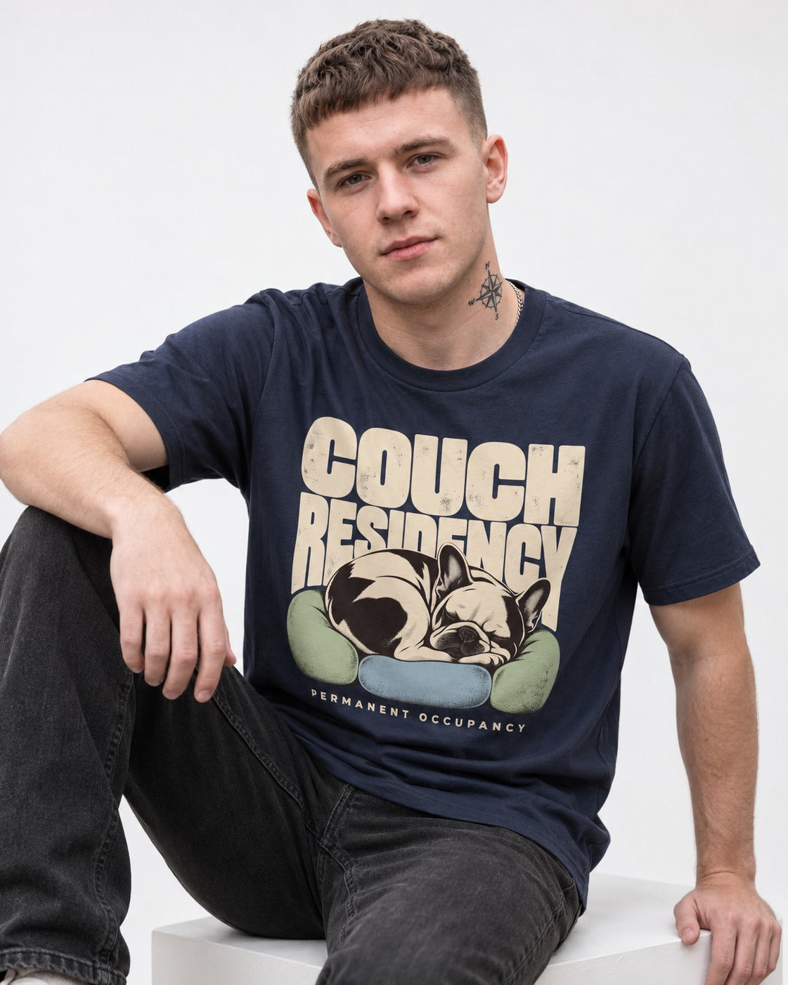 Frenchie Couch Residency Permanent Occupancy Cushion Graphic T-Shirt in Navy, worn by a seated model