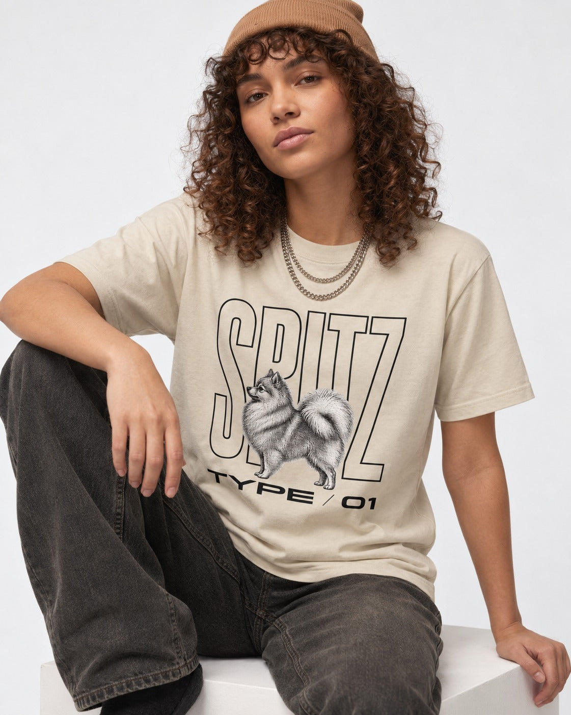 Pomeranian Spitz T-Shirt in Sand, worn by a seated model