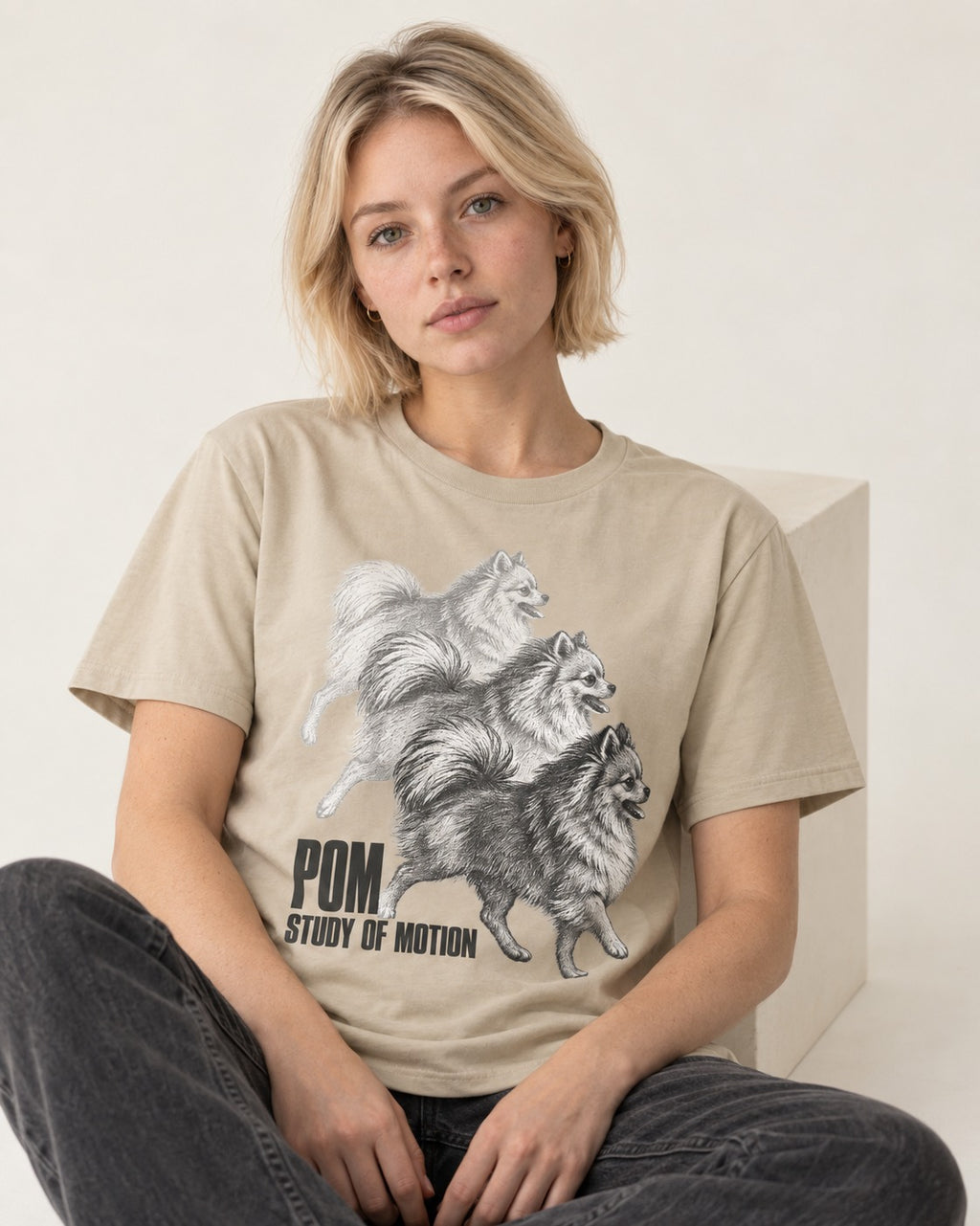 Pomeranian Study of Motion T-Shirt in Sand, worn by a seated model