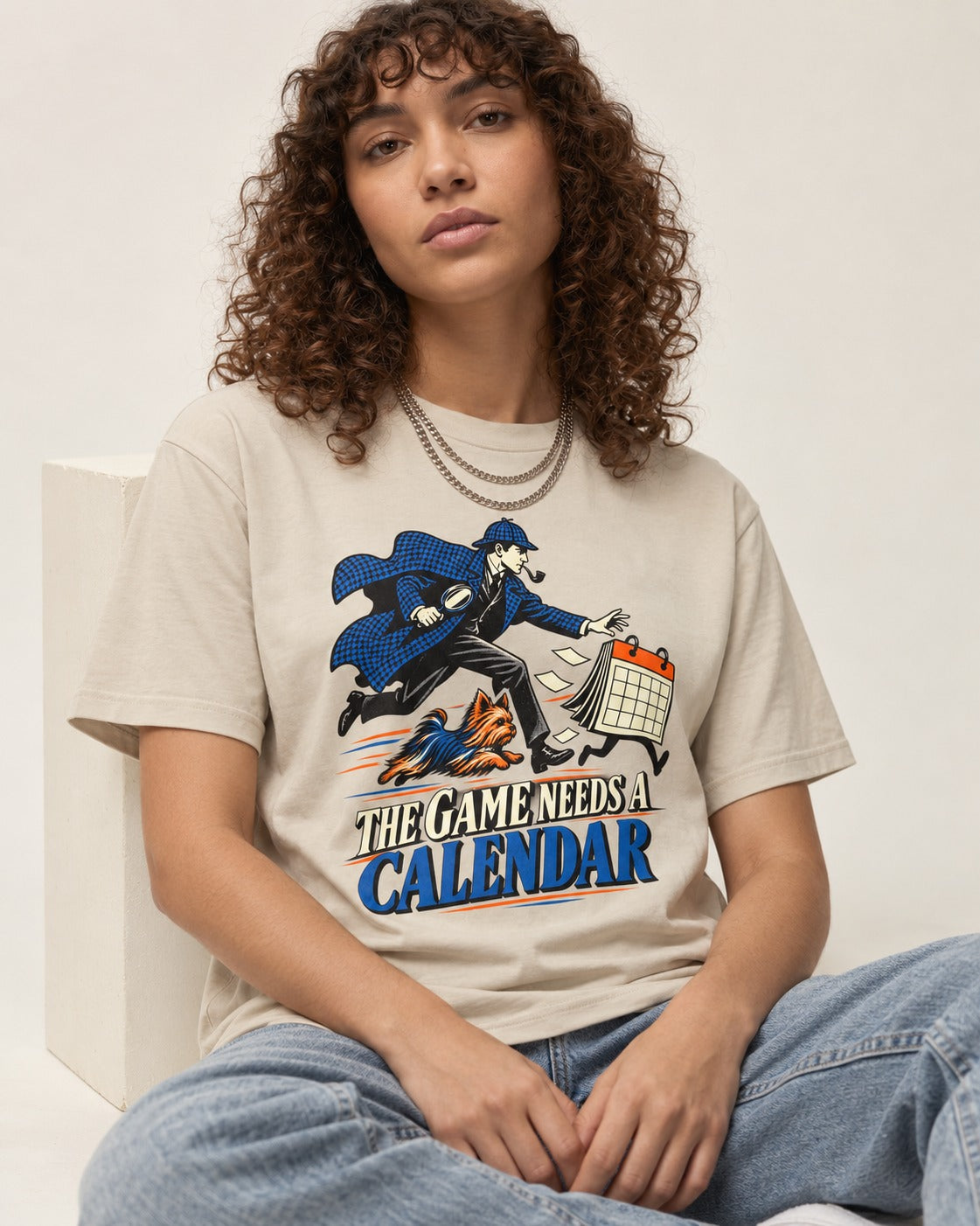 Yorkshire Terrier Game Needs a Calendar T-Shirt in Sand, worn by a seated model