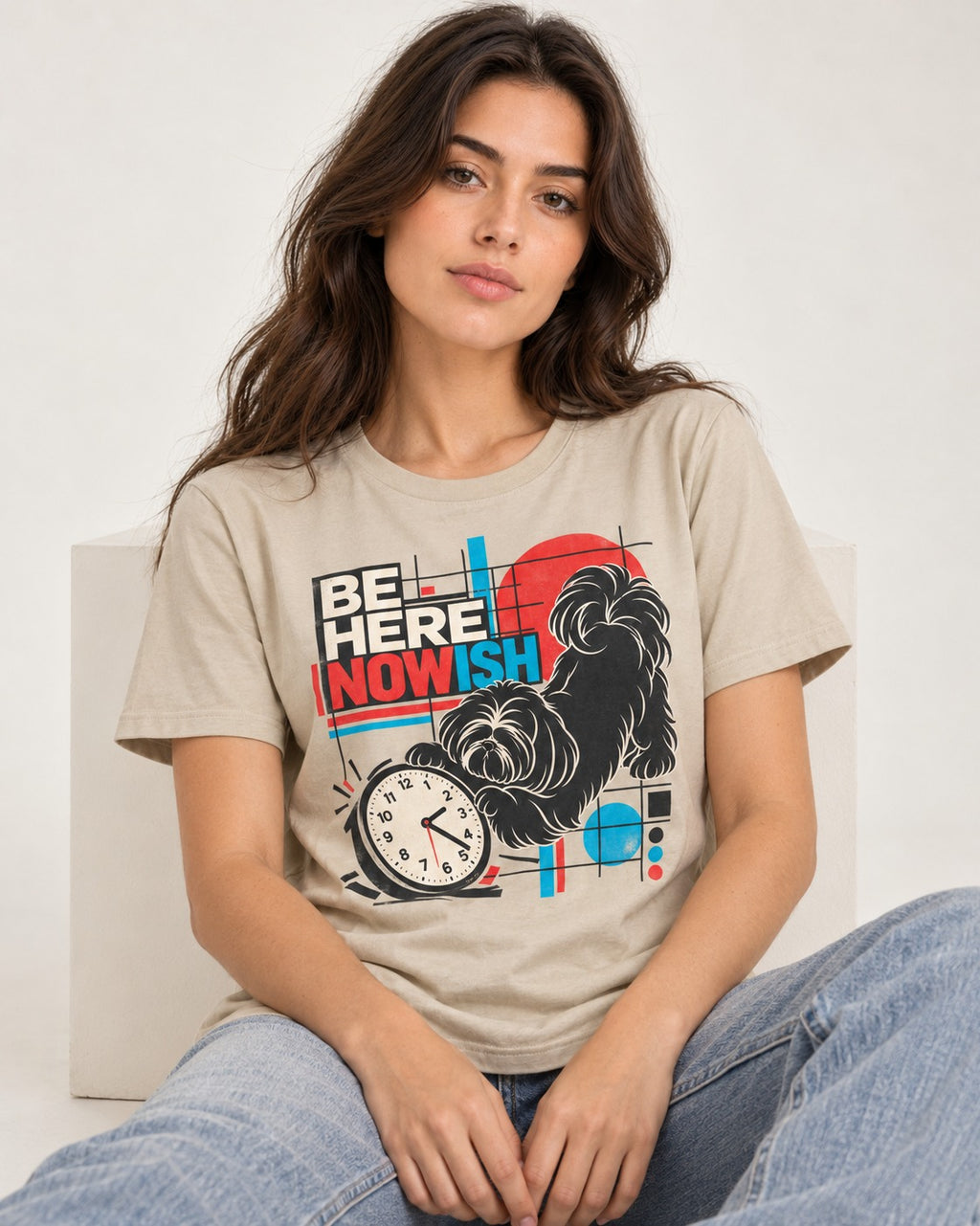 Be Here Nowish Shih Tzu T-Shirt in Sand, worn by a seated model