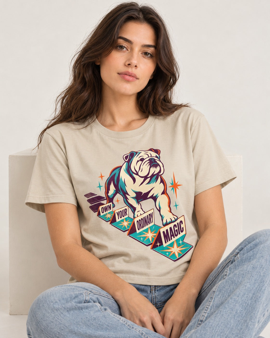 English Bulldog's Ordinary Magic T-Shirt in Sand, worn by a seated model