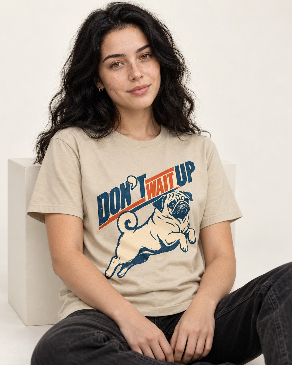 Don't Wait Up for Pug T-Shirt in Sand, worn by a seated model