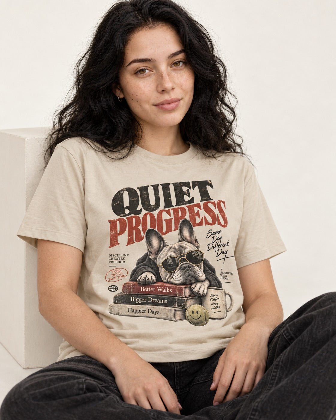 Quiet Progress Frenchie T-Shirt in Sand, worn by a seated model