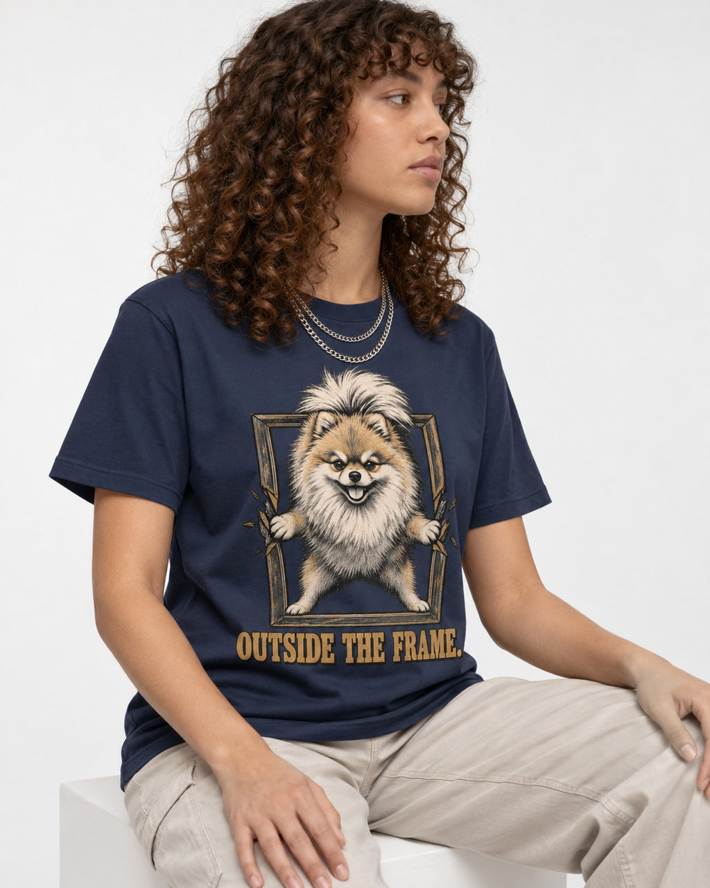 Pomeranian Outside the Frame Breakthrough Graphic T-Shirt in Navy, worn by a seated model