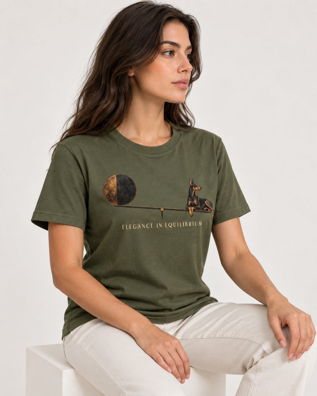 Doberman Elegance in Equilibrium Balance Graphic T-Shirt in Heather Military Green, worn by a seated model