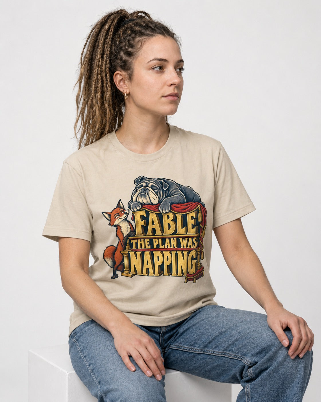 English Bulldog The Plan Was Napping T-Shirt in Sand, worn by a seated model