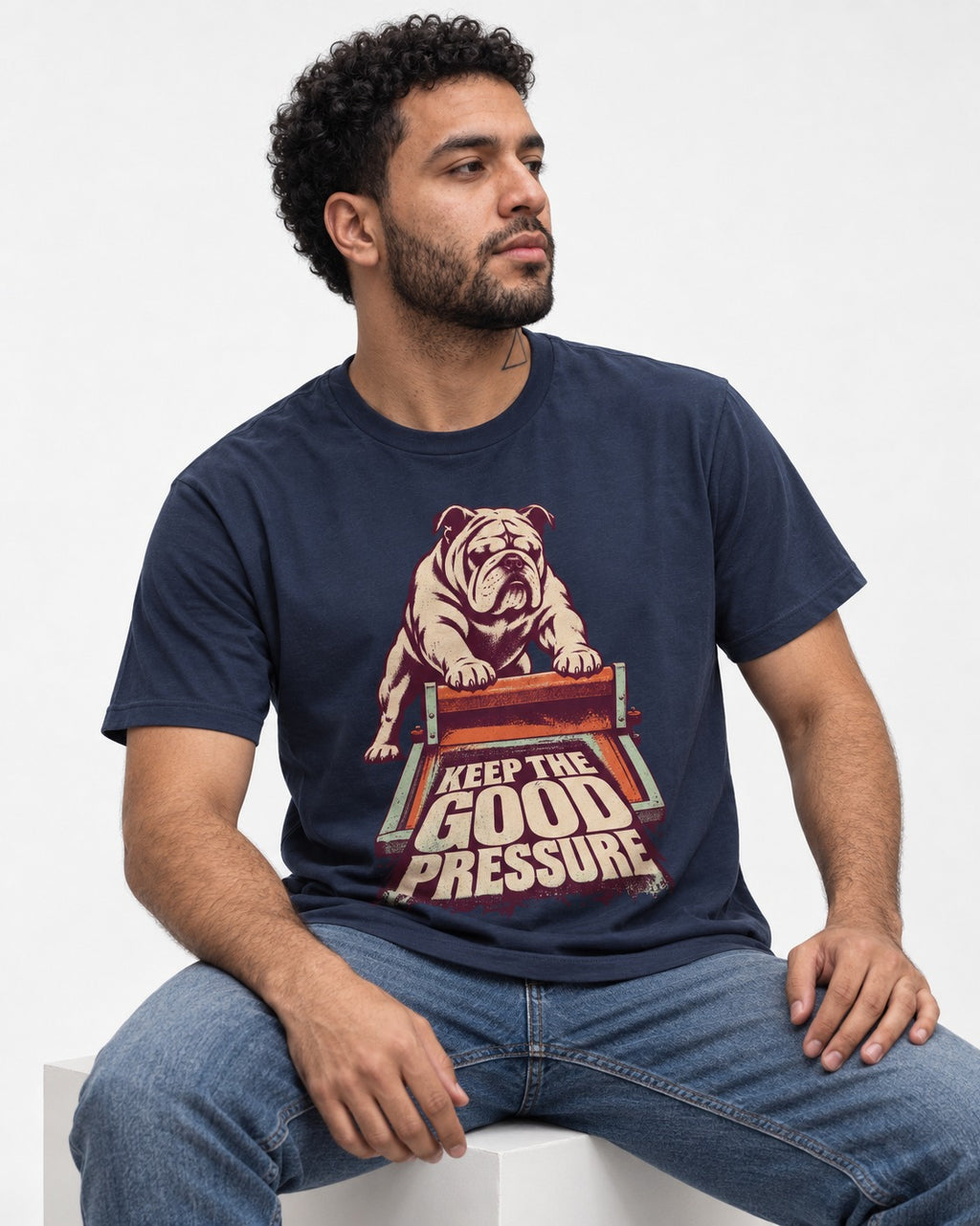 English Bulldog Keep the Good Pressure Printing Press Graphic T-Shirt in Navy, worn by a seated model