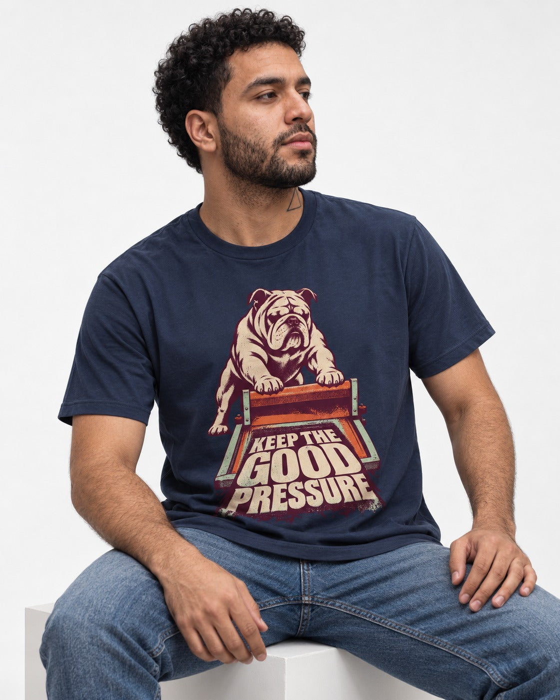 English Bulldog Keep the Good Pressure Printing Press Graphic T-Shirt in Navy, worn by a seated model