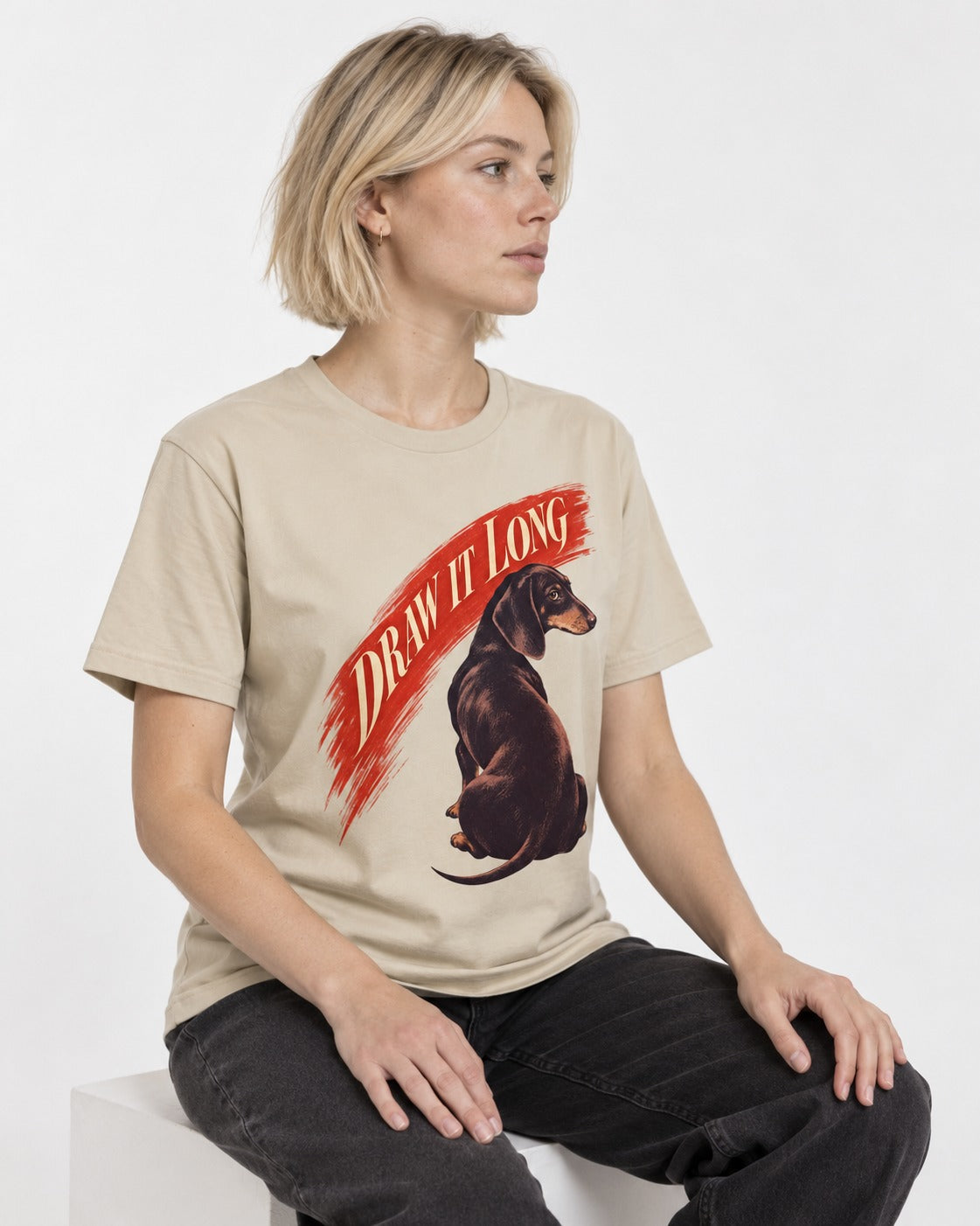 Draw It Long Dachshund T-Shirt in Sand, worn by a seated model