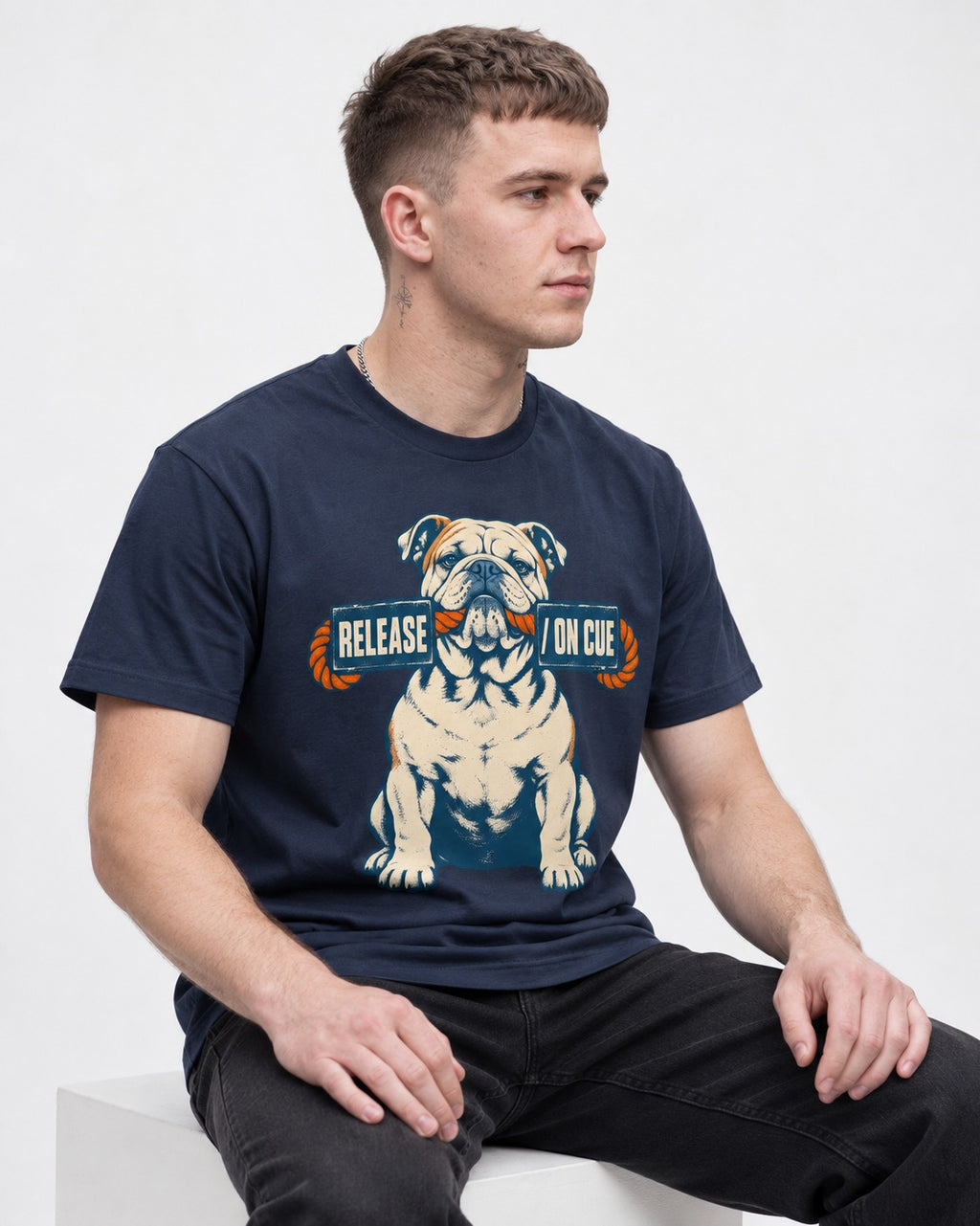 English Bulldog Release on Cue Rope Sign Graphic T-Shirt in Navy, worn by a seated model