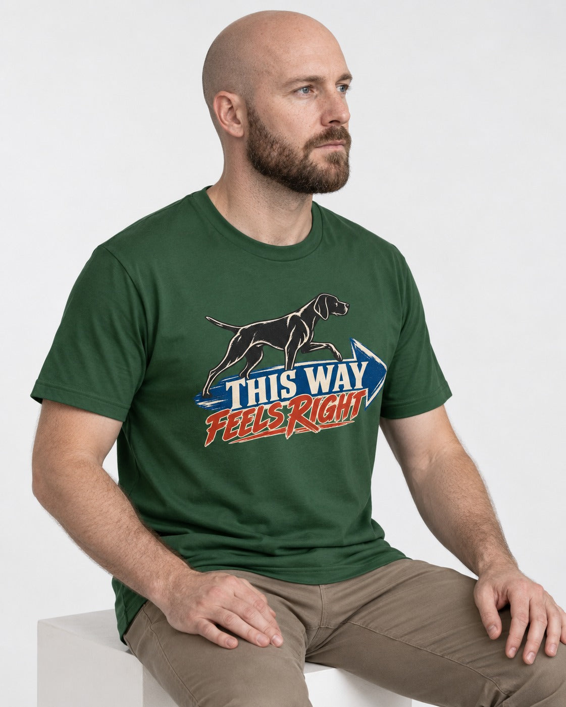 This Way Feels Right Arrow German Shorthaired Pointer Graphic T-Shirt in Forest Green, worn by a seated model