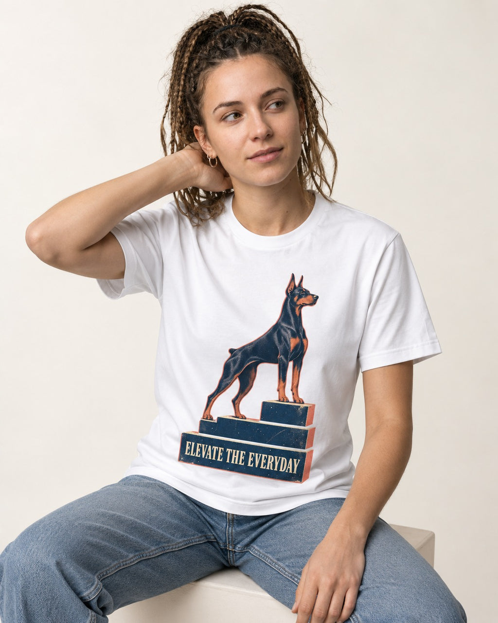 Doberman Elevate the Everyday Podium Graphic T-Shirt in White, worn by a seated model