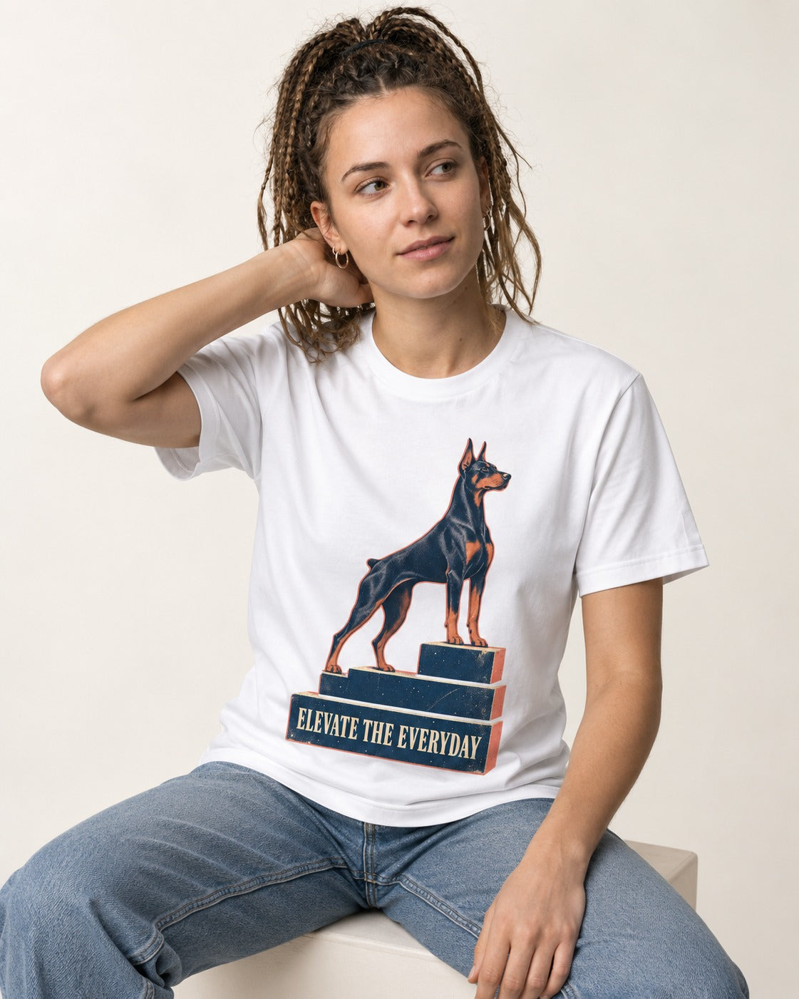 Doberman Elevate the Everyday Podium Graphic T-Shirt in White, worn by a seated model