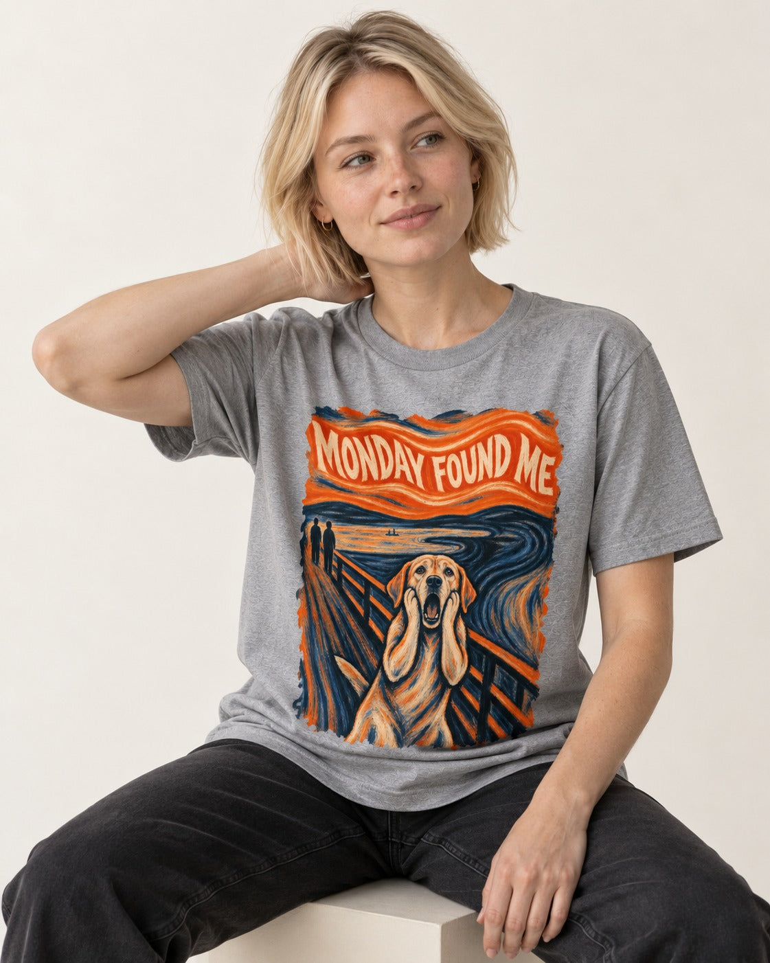 Labrador Retriever Monday Found Me Scream Parody Graphic T-Shirt in Sport Grey, worn by a seated model