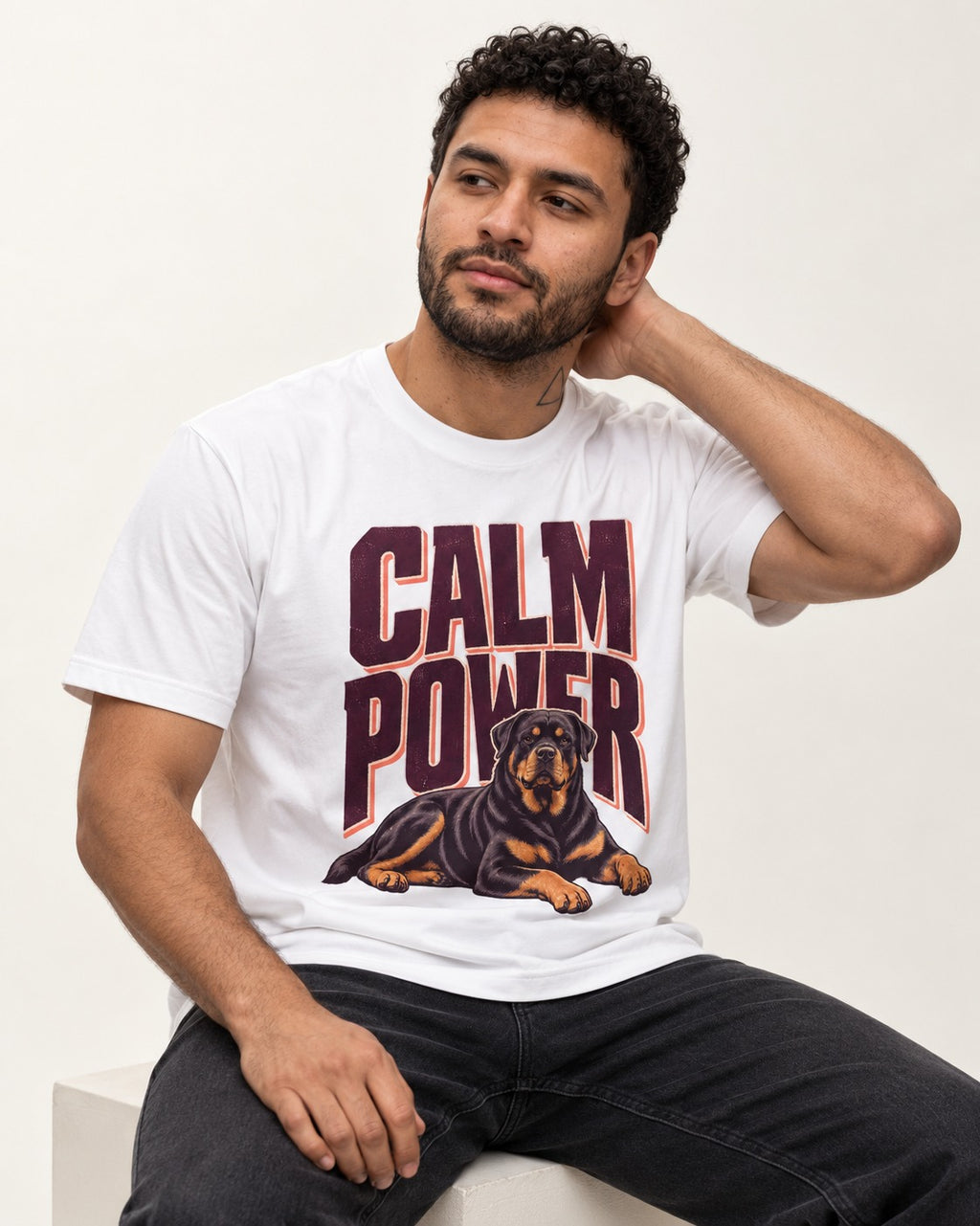 Rottweiler Calm Power Resting Dog Graphic T-Shirt in White, worn by a seated model