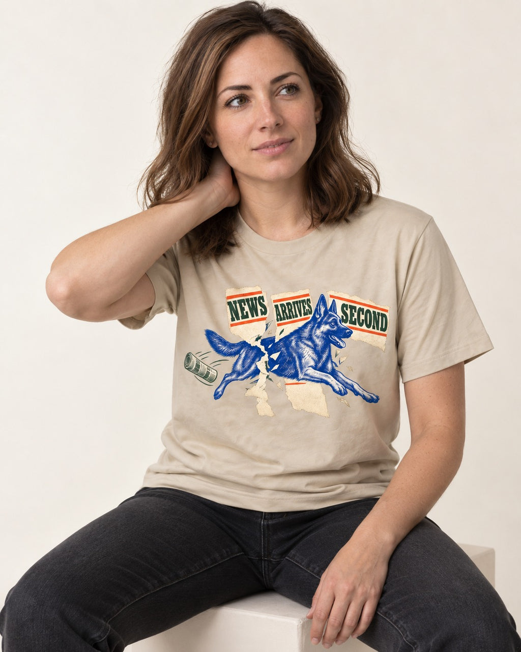 News Arrives Second German Shepherd Dog T-Shirt in Sand, worn by a seated model