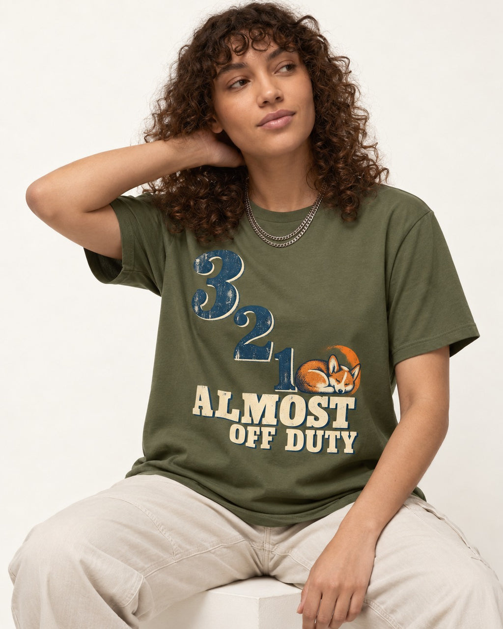 Corgi Almost Off Duty T-Shirt in Heather Military Green, worn by a seated model