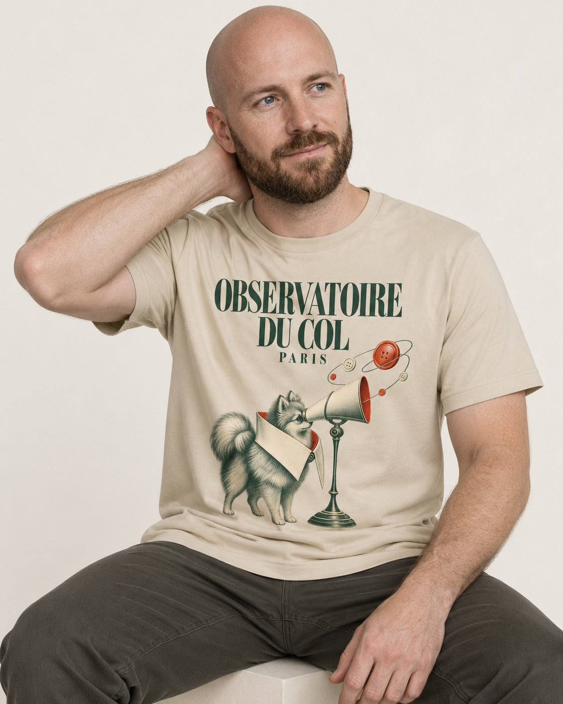 Pomeranian Observatoire Du Col T-Shirt in Sand, worn by a seated model