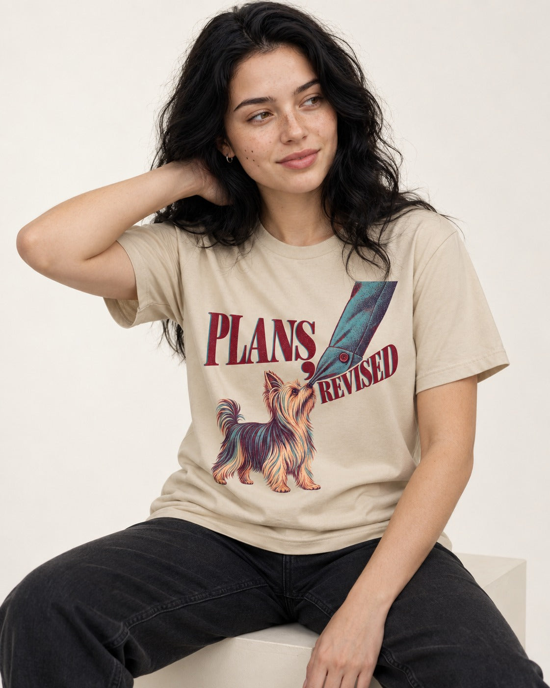 Yorkshire Terrier Plans Revised T-Shirt in Sand, worn by a seated model