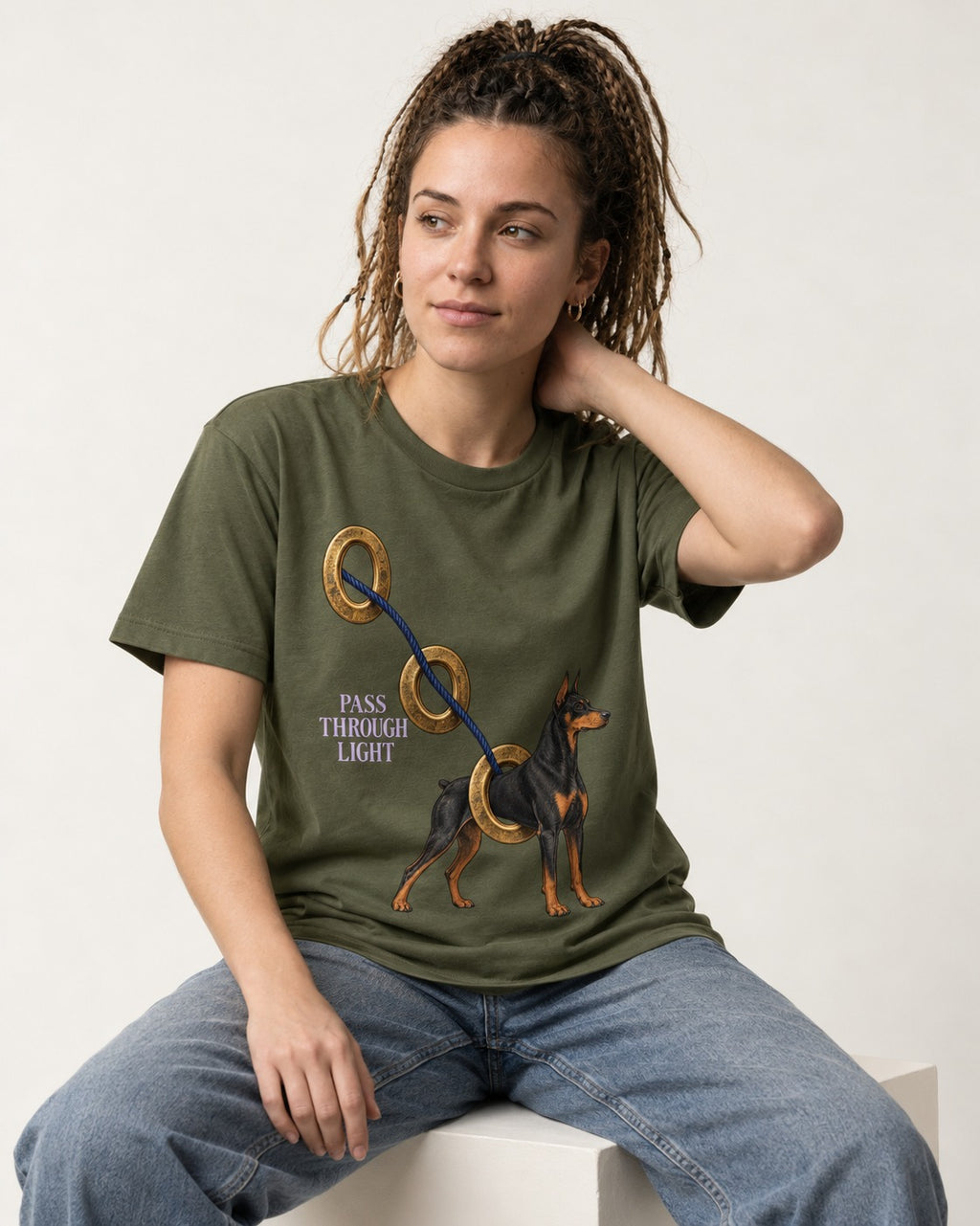 Doberman Pass Through Light Ring Graphic T-Shirt in Heather Military Green, worn by a seated model