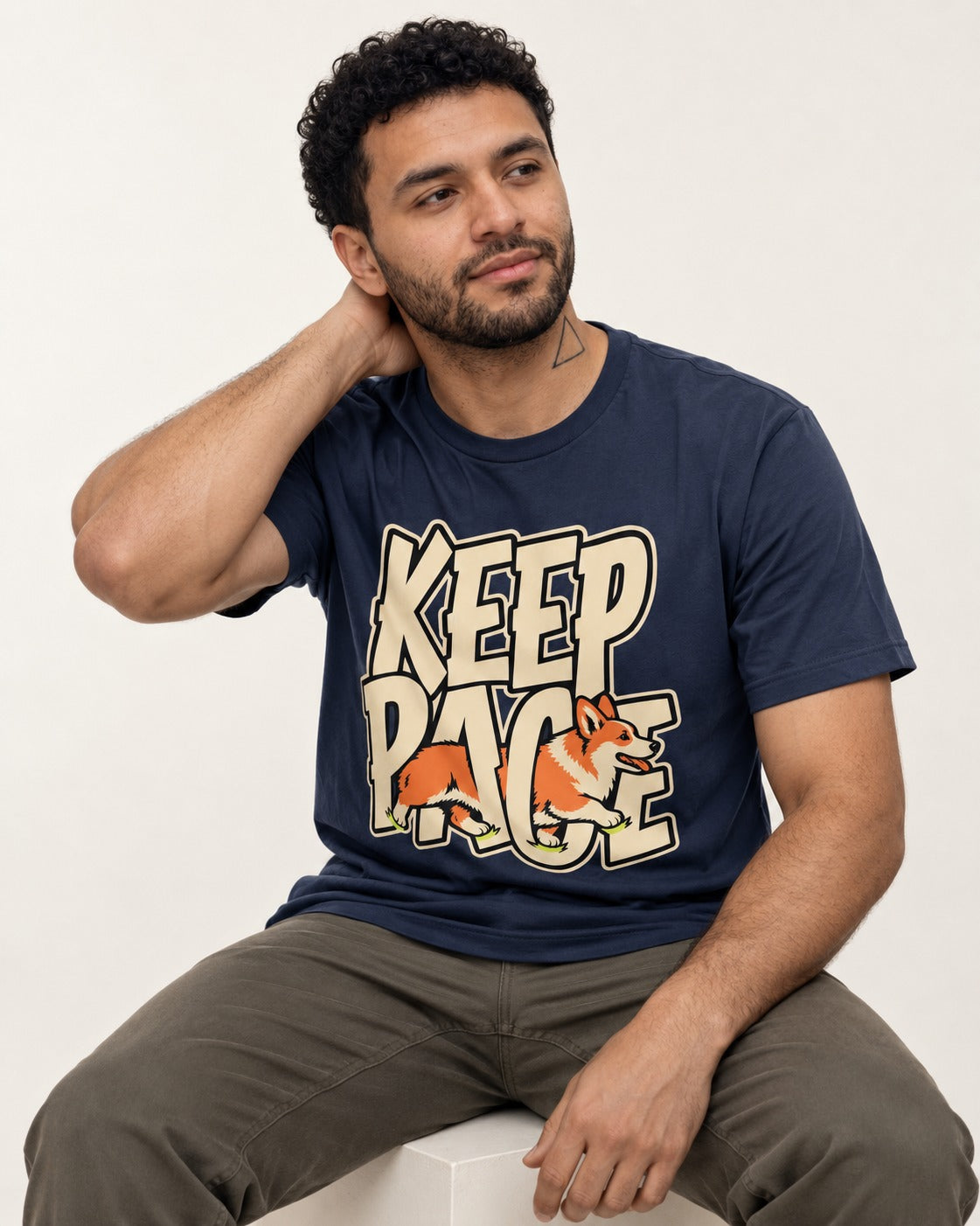 Corgi Keep Pace Running Typographic Graphic T-Shirt in Navy, worn by a seated model