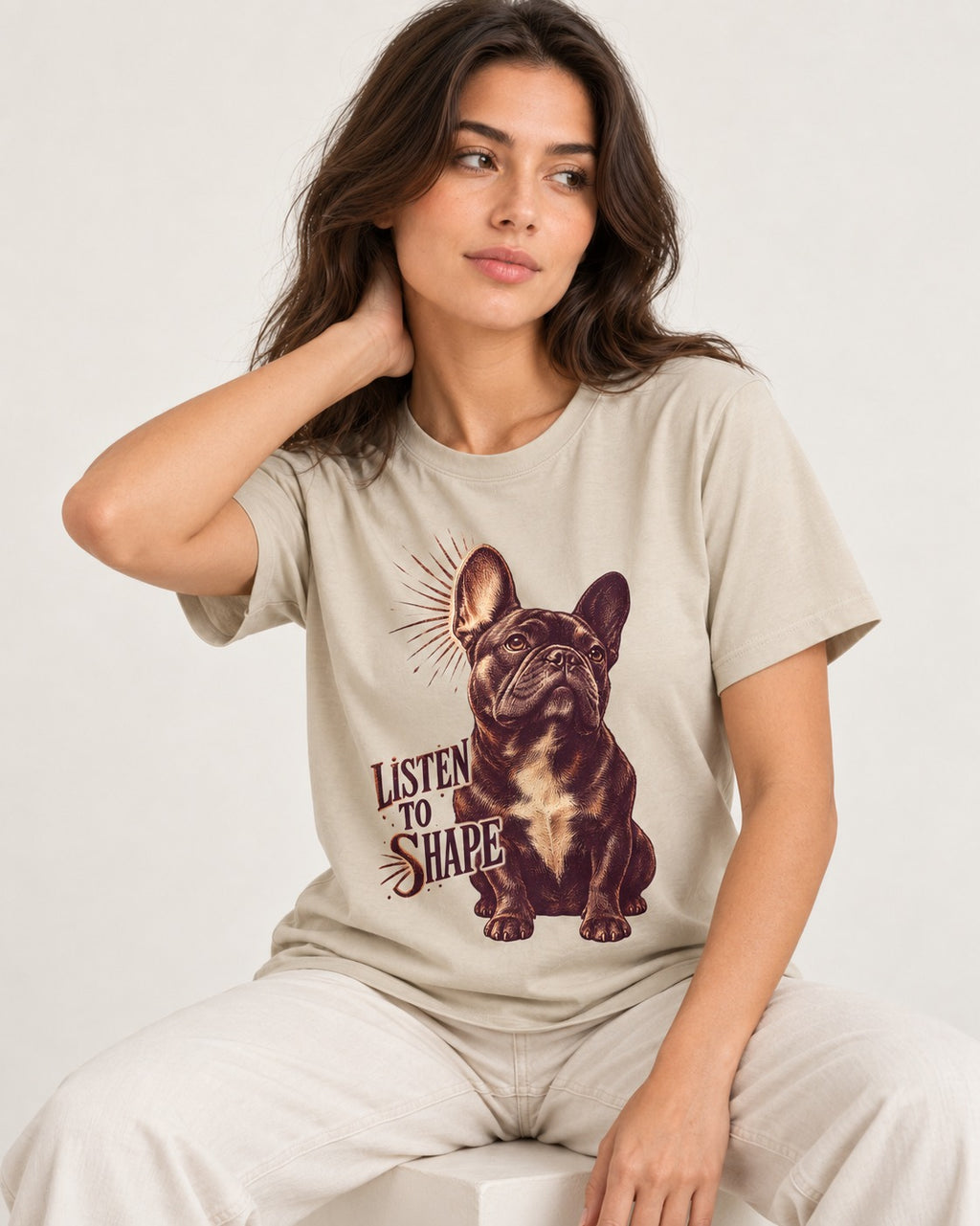 Listen to Shape Frenchie T-Shirt in Sand, worn by a seated model